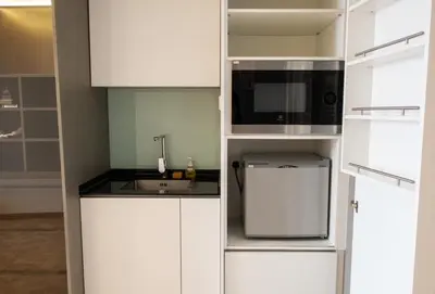 a kitchen with white cabinets and a microwave at Expressions Suite by Rudiman in Kuala Lumpur