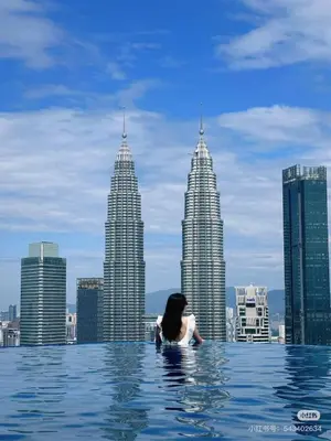 a woman in a infinity pool with a view of the city at \u4f0a\u987f\u9152\u5e97\u516c\u5bd3 in Kuala Lumpur