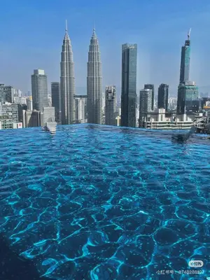 a infinity pool with a city skyline in the background at \u4f0a\u987f\u9152\u5e97\u516c\u5bd3 in Kuala Lumpur