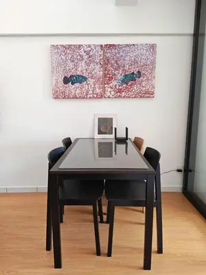 a dining room table with two chairs and a painting at Urban Designer's Duplex in Ampang
