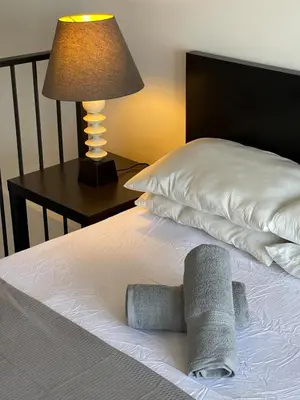 a bed with two towels on it with a lamp at Urban Designer's Duplex in Ampang