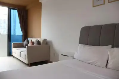 a bedroom with a bed and a couch and a chair at The Colony By Infinitum B in Kuala Lumpur