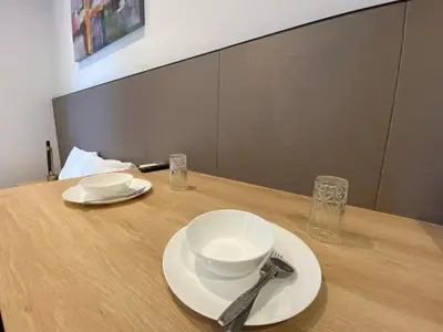 a wooden table with two plates and a fork and knife at The Colony By Infinitum T in Kuala Lumpur