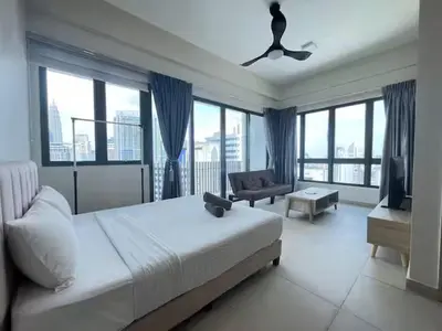 a bedroom with a bed and a couch and windows at The Colony By Infinitum F in Kuala Lumpur