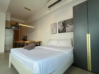 a large white bed in a room with a table at The Colony By Infinitum N in Kuala Lumpur