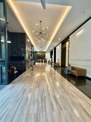 a large lobby with a wooden floor and a large chandelier at Chambers Suites Mrk in Kuala Lumpur