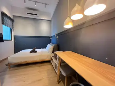 a bedroom with a bed and a wooden table at The Colony By Infinitum K in Kuala Lumpur