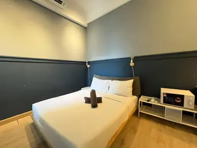 a bedroom with a large white bed with a blue wall at The Colony By Infinitum K in Kuala Lumpur