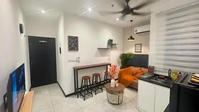 a kitchen and living room with a couch and a table at Comfy 2BR with FREE Parking at Neu Suites by OKBnB in Kuala Lumpur