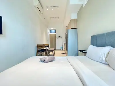a large white bed with a pink animal laying on it at The Colony By Infinitum J in Kuala Lumpur