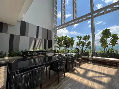 a restaurant with black chairs and a bar with a view at The Colony By Infinitum M in Kuala Lumpur