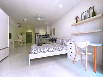 a bedroom with a bed and a desk and a kitchen at Mercu Summer Suites Bernice KLCC in Kuala Lumpur