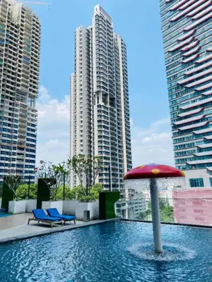 a pool with a red umbrella and some buildings at New 5 min Gleneagles Hospital 10 min KLCC in Kuala Lumpur