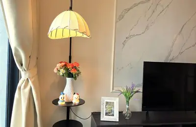 a living room with a vase of flowers and a lamp at New 5 min Gleneagles Hospital 10 min KLCC in Kuala Lumpur
