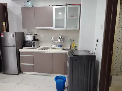 a small kitchen with a sink and a refrigerator at Regalia Suites in Kuala Lumpur