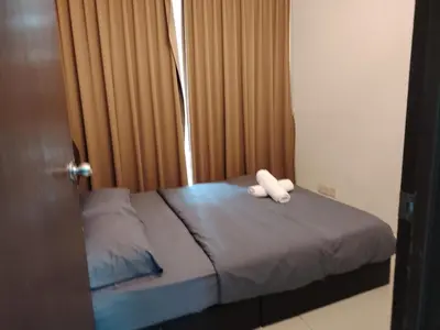 a bed with two white towels on top of it at Regalia Suites in Kuala Lumpur