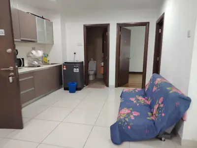 a living room with a couch and a kitchen at Regalia Suites in Kuala Lumpur