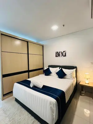 a bedroom with a large white bed with blue pillows at Cozy mercu summer suite 5mint WD KLCC luxury apartment free wifi, netfliix in Kuala Lumpur