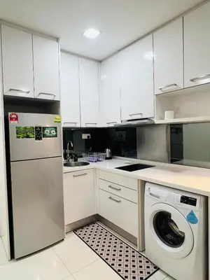 a kitchen with white cabinets and a washer at Cozy mercu summer suite 5mint WD KLCC luxury apartment free wifi, netfliix in Kuala Lumpur