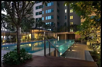 a swimming pool in front of a tall building at Cozy mercu summer suite 5mint WD KLCC luxury apartment free wifi, netfliix in Kuala Lumpur