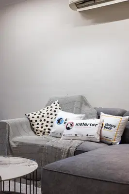 a living room with a gray couch with pillows at Royal Domain KL near Mont Kiara by Sleepy Bear in Kuala Lumpur