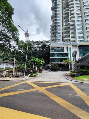 an empty street in front of a tall building at Suasana Bukit Ceylon with Panda Themes KL Tower View in Kuala Lumpur