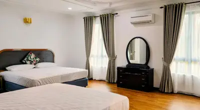 a bedroom with two beds and a mirror and a dresser at Gasing WheelHouse in Petaling Jaya