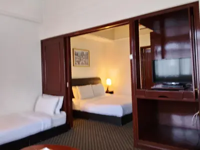 a hotel room with two beds and a flat screen tv at Afrin Service Suits at Berjaya Times Square in Kuala Lumpur