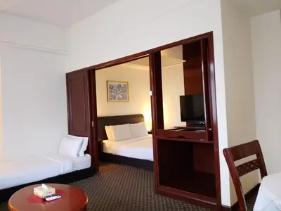 a hotel room with two beds and a television at Afrin Service Suits at Berjaya Times Square in Kuala Lumpur