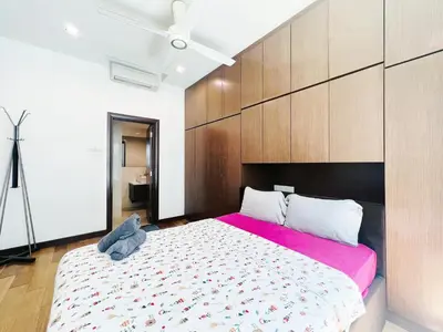 a bedroom with a large bed with a pink blanket at Regalia Studio apartment in Kuala Lumpur