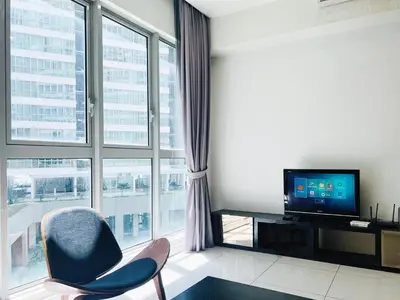 a living room with a tv and a large window at Regalia Studio apartment in Kuala Lumpur