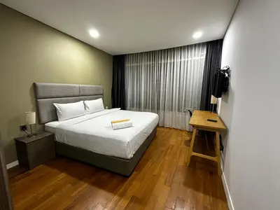 a bedroom with a bed and a table and a television at Vortex suites klcc by 2 bed 3 bed family suites vibes in Kuala Lumpur