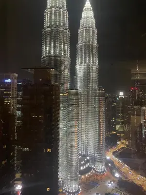 a view of the petronas twin towers at night at Modern 1BR Apartment with KLCC Twin Towers View in Kuala Lumpur