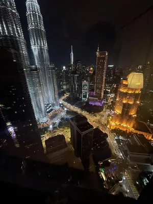 a view of a city at night with many tall buildings at Modern 1BR Apartment with KLCC Twin Towers View in Kuala Lumpur