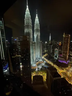 a view of the petronas towers at night at Modern 1BR Apartment with KLCC Twin Towers View in Kuala Lumpur