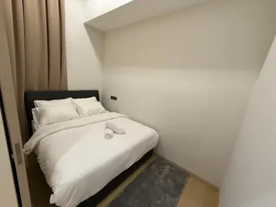 a small room with a bed with white sheets and pillows at Star Residance KLCC by Nexus in Kuala Lumpur