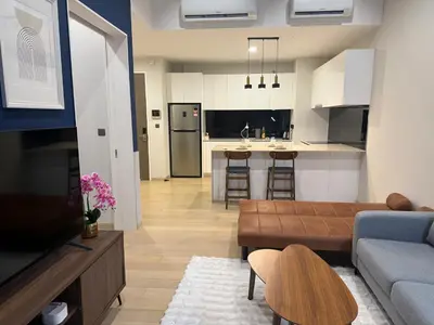 a living room with a couch and a kitchen at Star Residance KLCC by Nexus in Kuala Lumpur