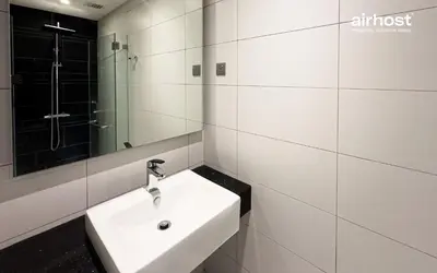 a white bathroom with a sink and a mirror at Anggun Residence KLCC by Airhost in Kuala Lumpur