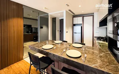 a kitchen with a large island in a room with chairs at Anggun Residence KLCC by Airhost in Kuala Lumpur
