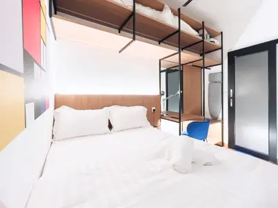 a bedroom with a white bed and a blue chair at Majestic Residence Infinity Pool with KLCC View in Kuala Lumpur