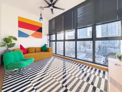 a living room with a couch and large windows at Majestic Residence Infinity Pool with KLCC View in Kuala Lumpur