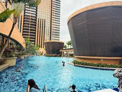 a large swimming pool in a city with people in it at Times Square Service Suites By Humira in Kuala Lumpur