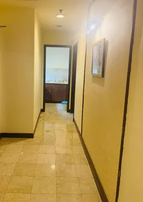 a hallway with yellow walls and a tile floor at Times Square Service Suites By Humira in Kuala Lumpur