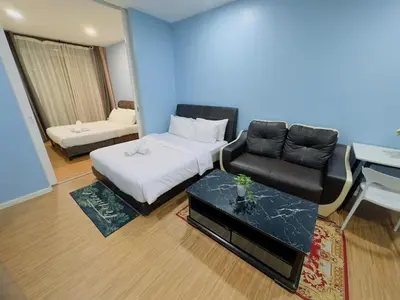 a bedroom with a bed and a chair and a desk at STANDARD HOME Taragon Puteri Bintang in Kuala Lumpur