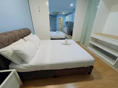a bedroom with a large bed with a white blanket at STANDARD HOME Taragon Puteri Bintang in Kuala Lumpur