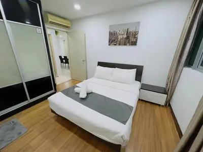 a bedroom with a bed with white sheets and pillows at STANDARD HOME Taragon Puteri Bintang in Kuala Lumpur