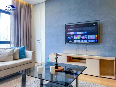 a living room with a couch and a tv on a wall at 188 Suites KLCC by VastHaven in Kuala Lumpur