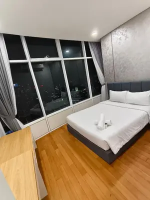 a bedroom with a large white bed in front of a window at Sky Suites KLCC by Global Family Suites in Kuala Lumpur