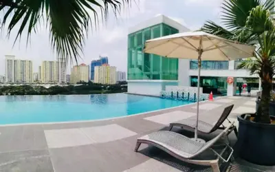 a pair of chairs and an umbrella next to a swimming pool at Zetapark Setapak Central Mall Home Sweet Home 3 in Kuala Lumpur