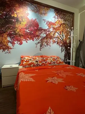 a bedroom with an orange bed with a tree mural at Zetapark Setapak Central Mall Home Sweet Home 3 in Kuala Lumpur